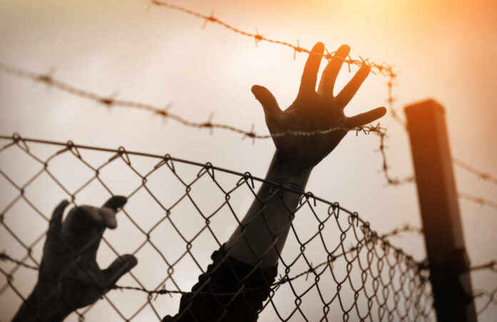Refugee,Men,And,Fence