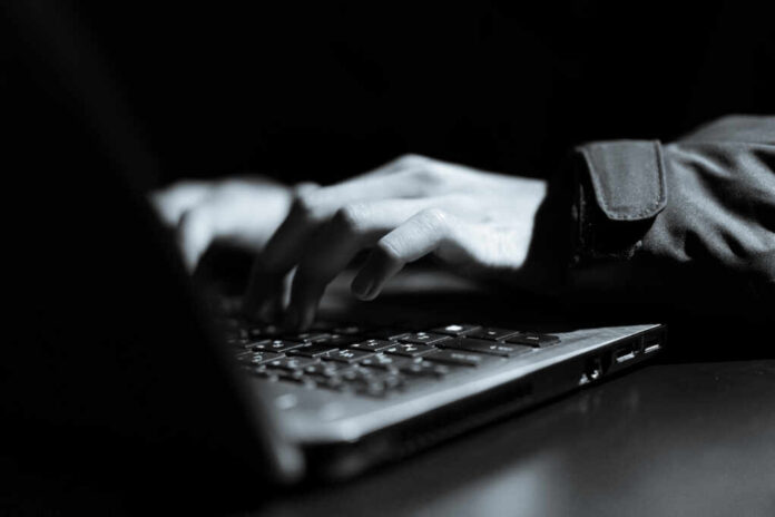 Hooded,Computer,Hacker,Stealing,Information,With,Laptop