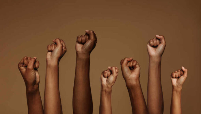 Cropped,Shot,Of,Hands,Raised,With,Closed,Fists.,Multiple,Hands