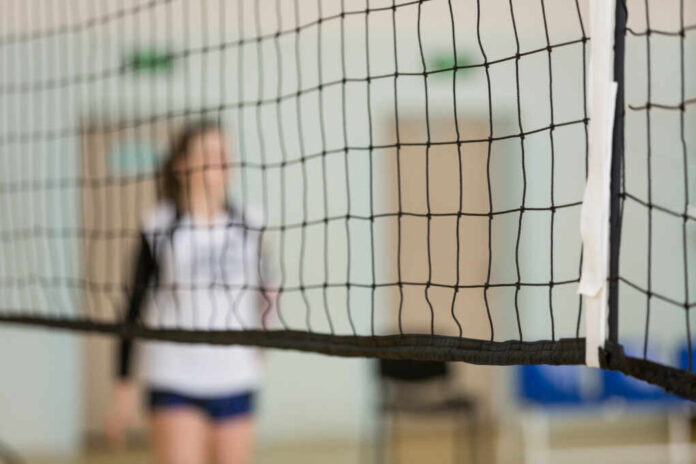 Volleyball,Net.,In,The,Background,Is,A,Volleyball,Player,,A