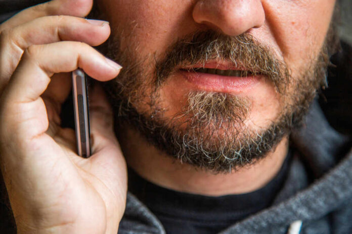 Close,Up,Portrait,Of,Bearded,Man,Talking,On,Smart,Phone,