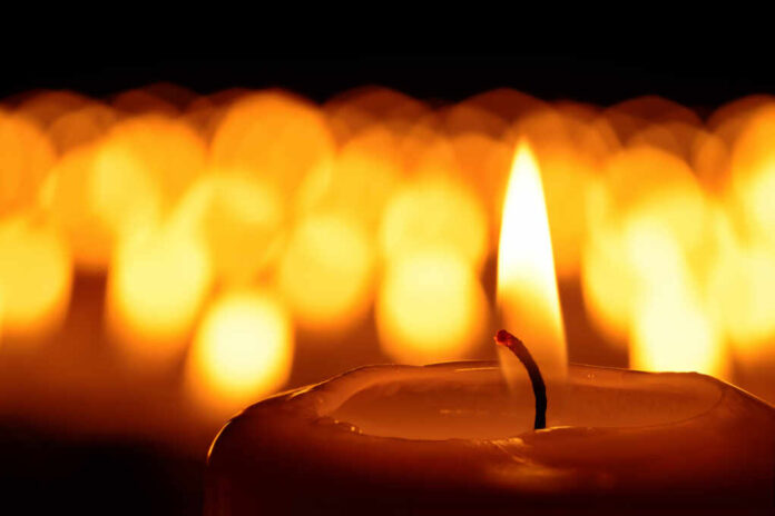 Candle,In,Front,Of,Many,Defocused,Candleflames,Creating,A,Spiritual