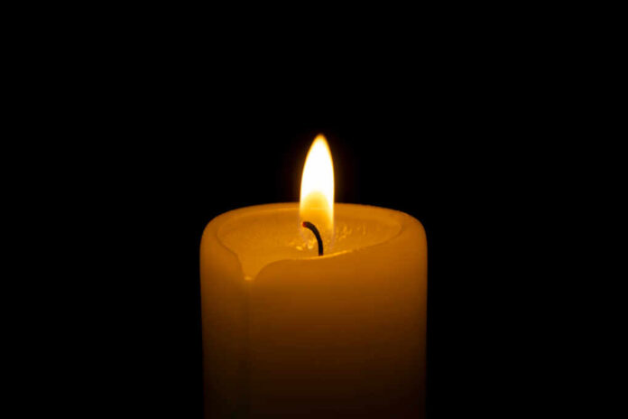 Close,Up,Of,Orange,Wax,Candle,Flame,On,A,Dark