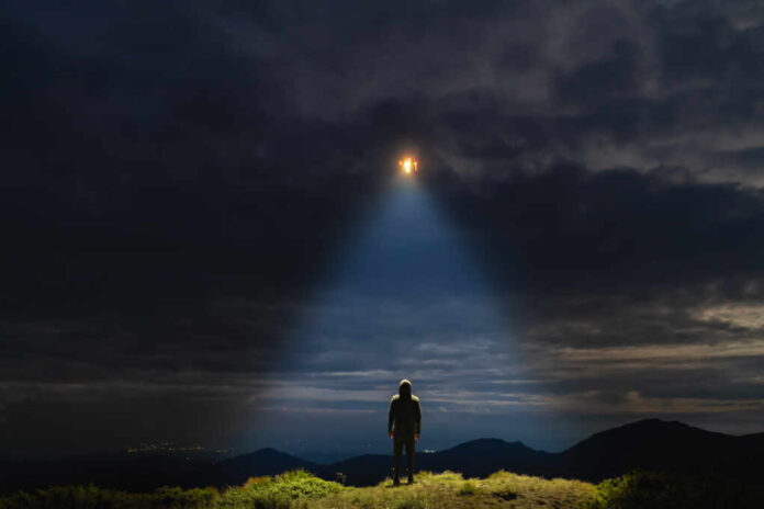 The,Ufo,Shines,On,A,Male,Standing,On,The,Mountain
