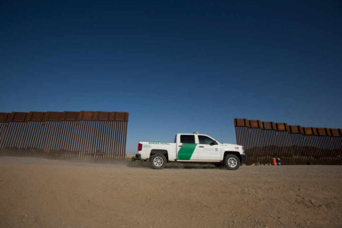 A,Border,Patrol,Truck,Drives,By,The,Wall,Separating,The