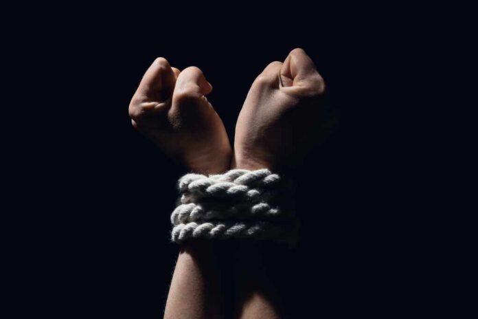 Tied,Together,Hands,Of,Hostage,On,Dark,Background