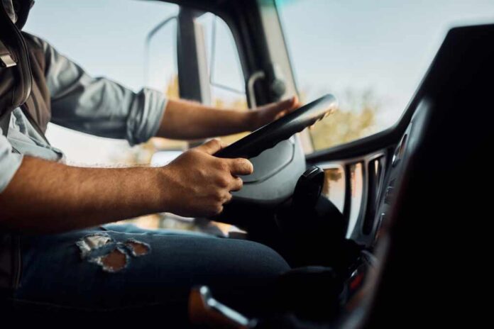 Close,Up,Of,Truck,Driver,Behind,The,Steering,Wheel,In