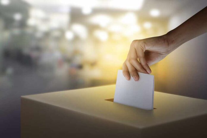 Woman,Hand,Throws,Voting,Ballot,Paper,In,Ballot,Box,,Concept