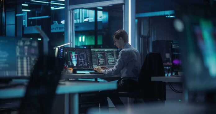 Caucasian,Quantum,Computer,Engineer,Working,In,A,Dark,Office,In