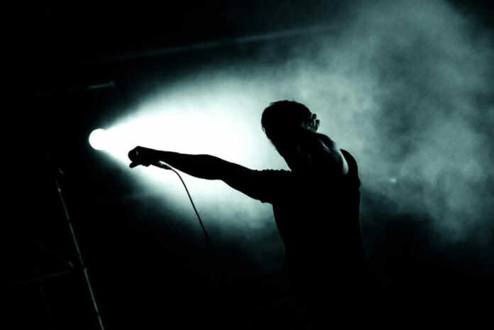 Silhouette,Of,A,Singer,Holding,Microphone,In,Stage,Lights