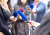 DC’s Alleged Media Silence: Fact or Fiction? Reporters holding microphones during an interview