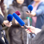 Reporters holding microphones during an interview