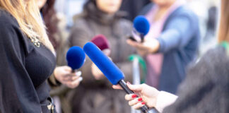 Reporters holding microphones during an interview