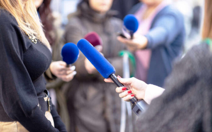 Reporters holding microphones during an interview