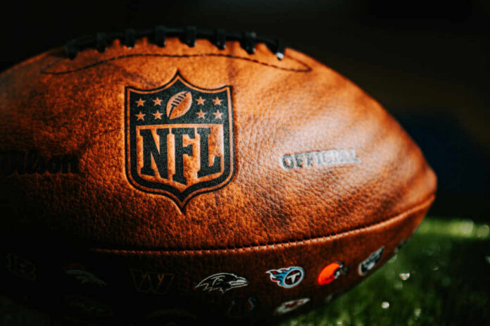 Close-up of an official NFL football with team logos and leather texture