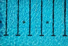 Aerial view of a swimming pool with clear blue water and lane markers