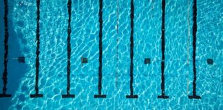 Aerial view of a swimming pool with clear blue water and lane markers