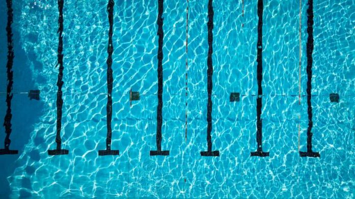 Aerial view of a swimming pool with clear blue water and lane markers