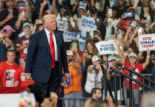 Donald Trump at a political rally with supporters holding signs