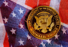 A commemorative coin featuring the presidential seal and the name Donald Trump on an American flag background