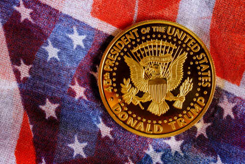 A commemorative coin featuring the presidential seal and the name Donald Trump on an American flag background