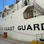 Side view of a U.S. Coast Guard ship docked at a port