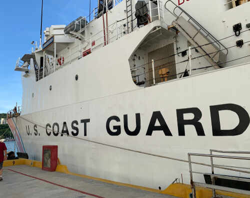 Side view of a U.S. Coast Guard ship docked at a port