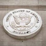 Seal of the United States Embassy displayed on a wall