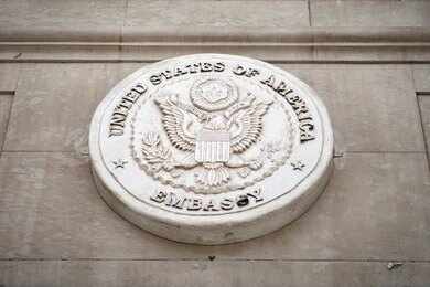Seal of the United States Embassy displayed on a wall