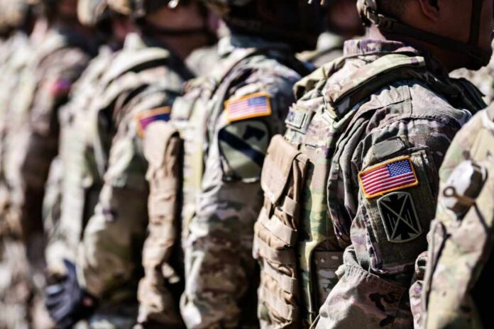Line of soldiers in military uniforms with American flag patches