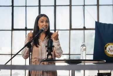 A woman speaking passionately at a podium with a microphone