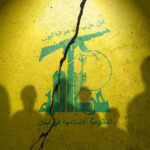 Silhouettes of two figures against a yellow background featuring Hezbollah's emblem