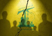 Silhouettes of two figures against a yellow background featuring Hezbollah's emblem