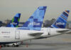 Three jetBlue aircraft tails lined up at an airport