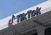 TikTok logo displayed on a building exterior against a blue sky