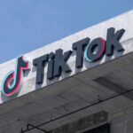 TikTok logo displayed on a building exterior against a blue sky
