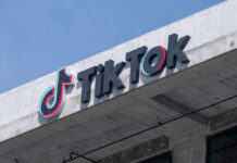 TikTok logo displayed on a building exterior against a blue sky