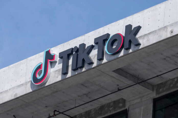 TikTok logo displayed on a building exterior against a blue sky