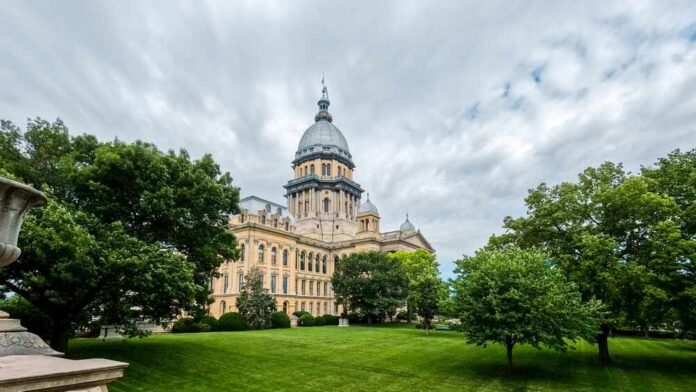 Historic government building surrounded by trees and grass under a cloudy sky