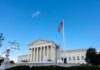 Supreme Court Eyes Gun Ban for Millions U.S. Supreme Court building with American flag and blue sky