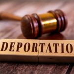 Wooden blocks spelling 'DEPORTATION' next to a gavel