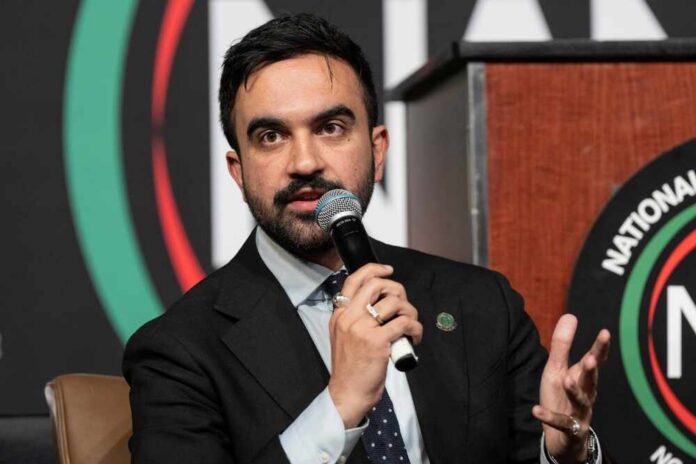 A speaker at a conference holding a microphone and gesturing while speaking