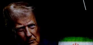 Close-up portrait of a political figure with the Iranian flag in the background