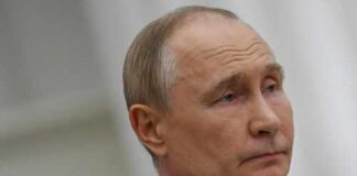 A serious-looking man in formal attire with a neutral expression