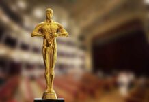 Golden Oscar trophy displayed in a theater setting