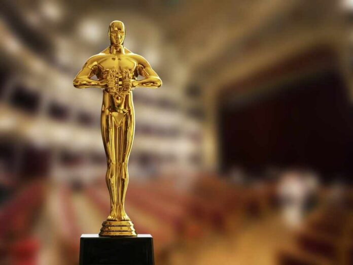 shutterstock_2715699001.jpg Golden Oscar trophy displayed in a theater setting