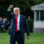 Trump Unveils $300B Refinery Plan – Game Changer? A political figure walking outdoors with a raised fist