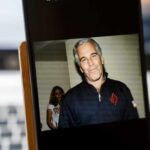 A man in casual attire smiling at the camera