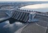 Iran’s Water War Threat—Gulf Cities in Panic? Aerial view of a large dam with water flowing through its gates