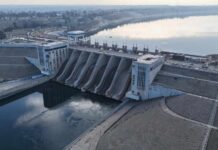 Aerial view of a large dam with water flowing through its gates